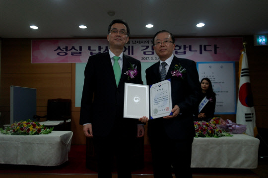 현재빈 용산세무서장(왼쪽)과 이갑수 시스원 대표가 모범 납세자상을 수상 후 기념촬영을 하고 있다.  시스원 제공
